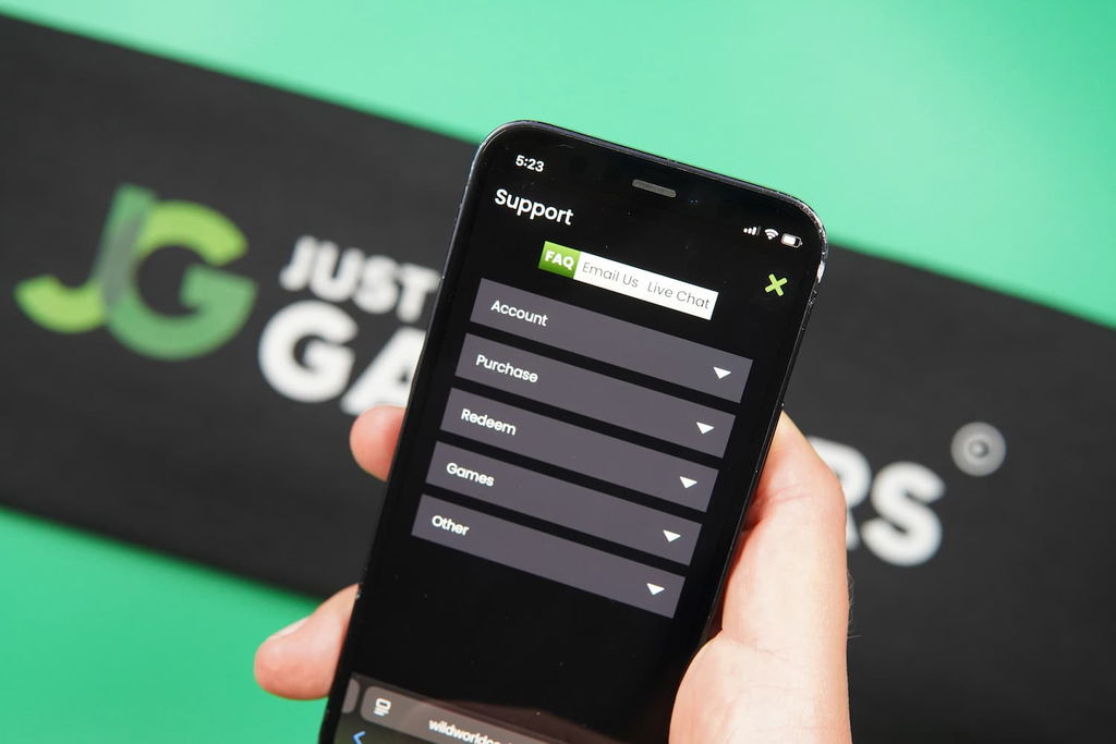 Patrik Lidin holding an iPhone with the Wild World Casino Support page loaded on the webpage.