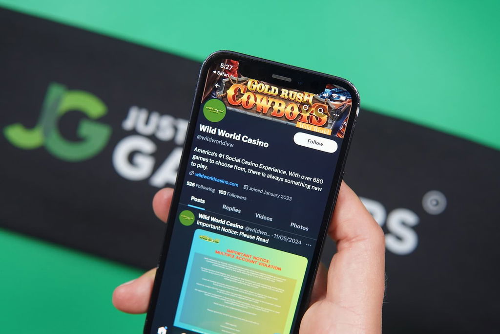 Patrik Lidin holding an iPhone with the Wild World Casino X social media page loaded on the webpage.