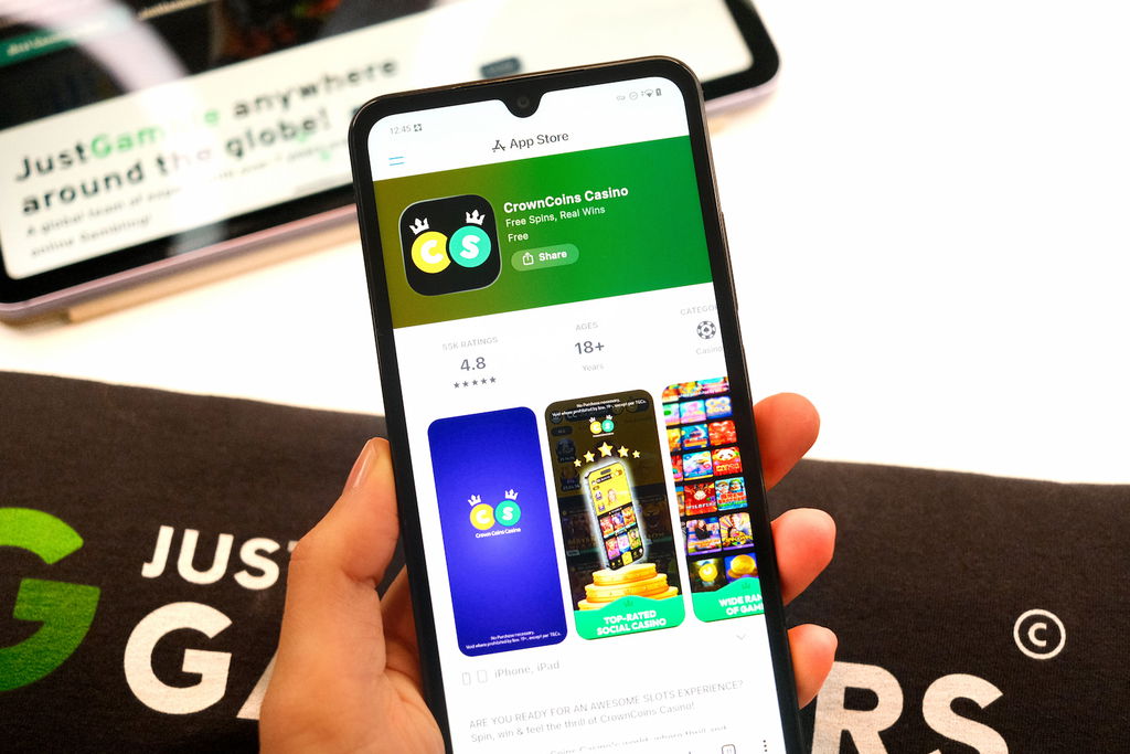 Photo of two mobile devices with WOW Vegas and Crown Coins Casino landing page loaded.