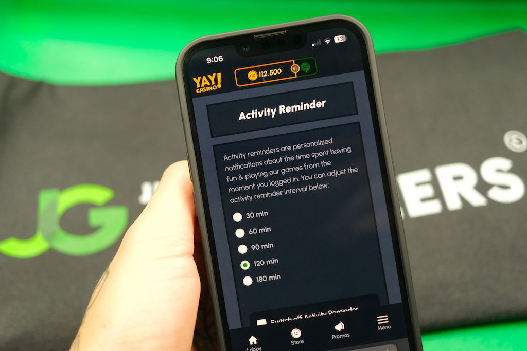 Patrik Lidin holding an iPhone with the Yay casino activity reminder page loaded on the webpage.