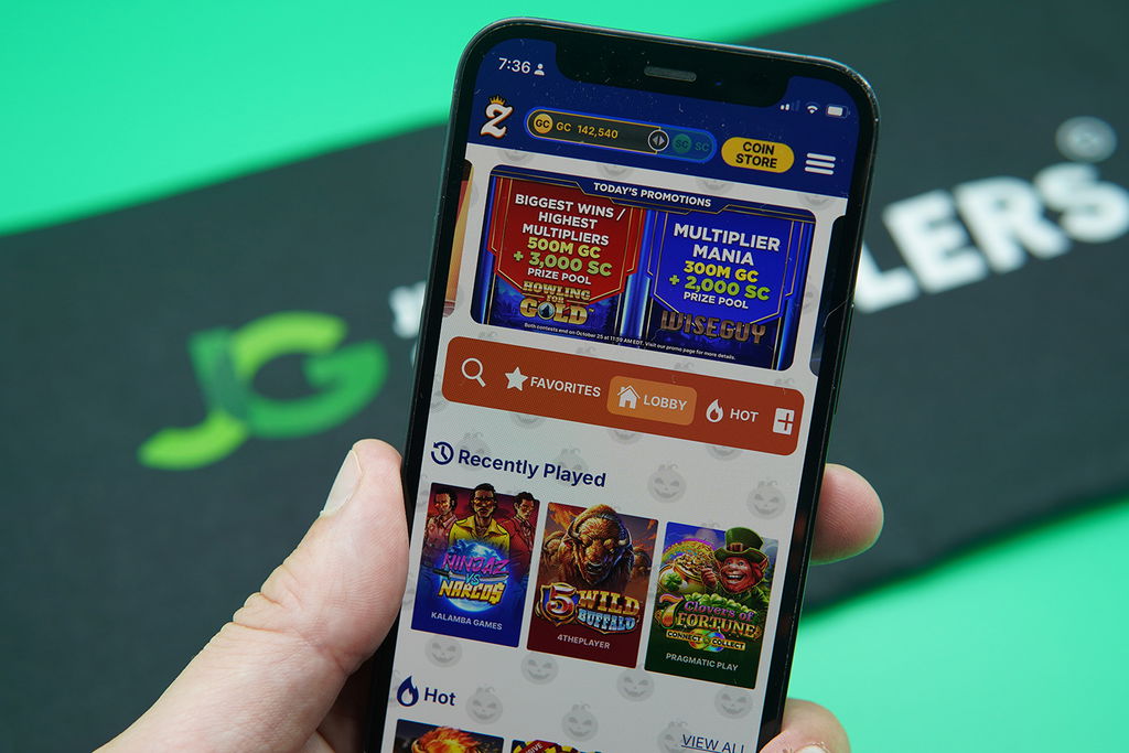 Photo of Patrik Lidin holding an iPhone to show how the Zula Casino looks.